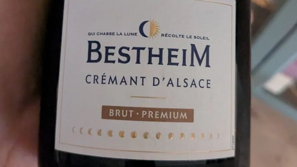 Étiquette du Crémant d'Alsace Brut Premium de Bestheim, avec la devise Qui chasse la lune récolte le soleil et une frise de phases de lune